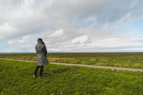 France, Bretagne, Finistere, Crozon peninsula, woman on meadow at the coast - UUF006693