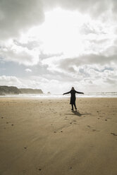France, Bretagne, Finistere, Crozon peninsula, woman standing on the beach with outstretched arms - UUF006700