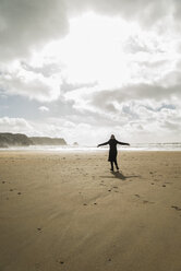 Frankreich, Bretagne, Finistere, Halbinsel Crozon, Frau am Strand stehend mit ausgestreckten Armen - UUF006700