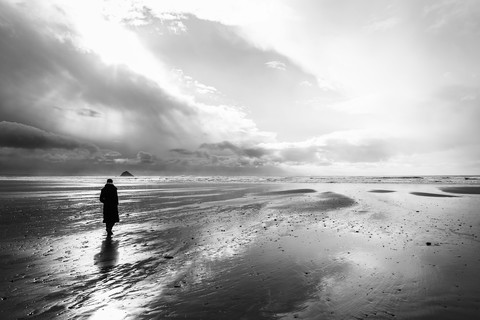 France, Bretagne, Finistere, Crozon peninsula, woman walking on the beach stock photo