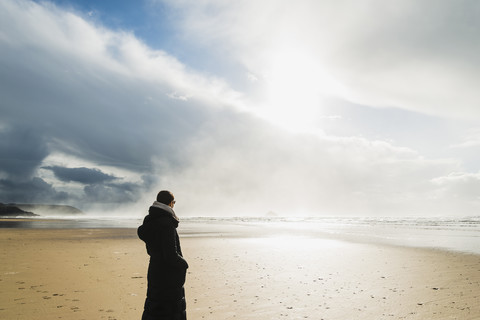 Frankreich, Bretagne, Finistere, Halbinsel Crozon, Frau steht am Strand, lizenzfreies Stockfoto
