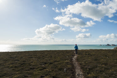 France, Bretagne, Finistere, Crozon peninsula, woman walking at the coast - UUF006722