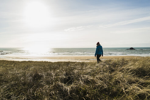 France, Bretagne, Finistere, Crozon peninsula, woman walking at the coast - UUF006735