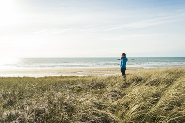 Frankreich, Bretagne, Finistere, Halbinsel Crozon, Frau steht an der Küste - UUF006736