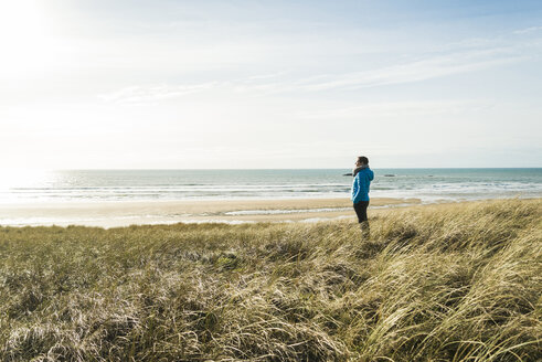 France, Bretagne, Finistere, Crozon peninsula, woman standing at the coast - UUF006736