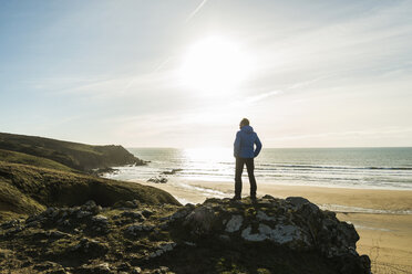 Frankreich, Bretagne, Finistere, Halbinsel Crozon, Mann steht auf einem Felsen an der Küste - UUF006739