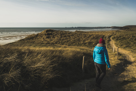 Frankreich, Bretagne, Finistere, Halbinsel Crozon, Frau beim Spaziergang an der Küste, lizenzfreies Stockfoto