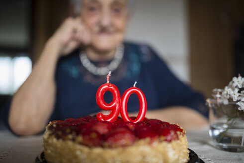 Kerzen auf einer Geburtstagstorte einer älteren Frau, die ihren neunzigsten Geburtstag feiert - RAEF000929