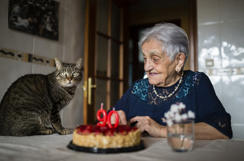 Senior woman celebrating ninetieth birthday with her cat stock photo