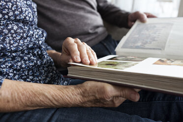Hände eines älteren Paares halten ein Fotoalbum, Nahaufnahme - RBF004125