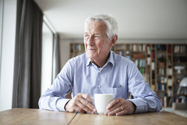 Porträt eines nachdenklichen älteren Mannes, der mit einer Tasse Kaffee am Tisch sitzt und durch das Fenster schaut - RBF004177