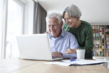 Senior couple using laptop at home - RBF004181