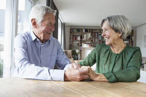 Glückliches älteres Paar hält sich zu Hause an den Händen - RBF004185