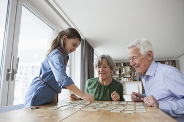 Little girl playing memory with her grandparents at home - RBF004196