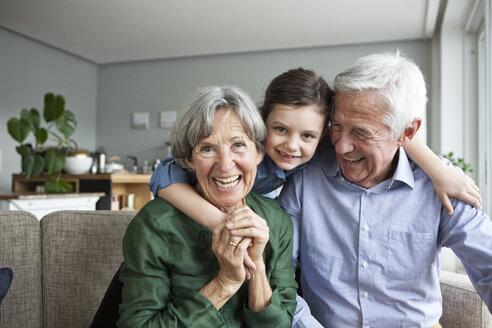 Family portrait of grandparents and their granddaughter at home - RBF004219