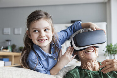 Senior woman and her granddaughter having fun with Virtual Reality Glasses at home - RBF004223