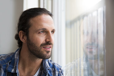 Man looking out of window - FKF001708