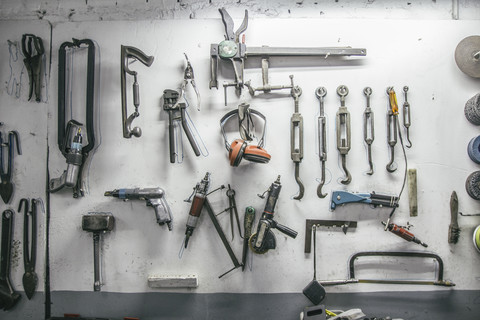 Werkzeuge hängen an der Wand einer Werkstatt, lizenzfreies Stockfoto