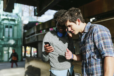 UK, London, zwei beste Freunde schauen etwas auf dem Smartphone - BOYF000122