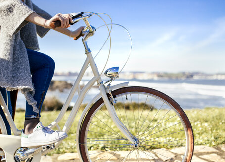 Woman riding bicycle at the coast - MGOF001488