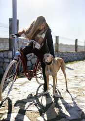 Junge Frau mit Fahrrad und Windhund - MGOF001489