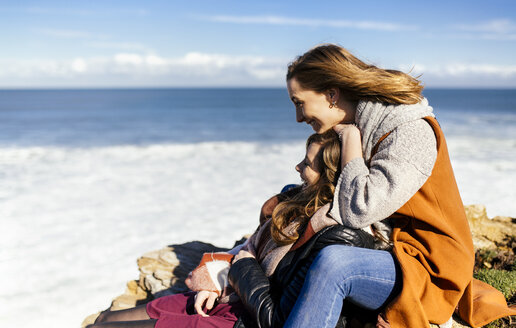Spanien, Gijon, zwei junge Frauen amüsieren sich am Meer - MGOF001494