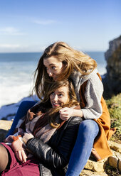 Spanien, Gijon, zwei junge Frauen amüsieren sich am Meer - MGOF001495
