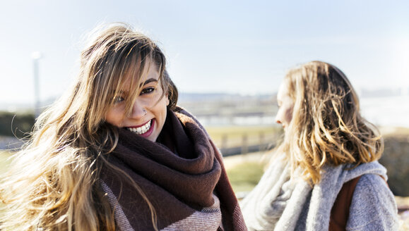 Porträt einer glücklichen jungen Frau mit Freundin im Freien - MGOF001499