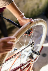 Young woman repairing her bicycle - MGOF001516