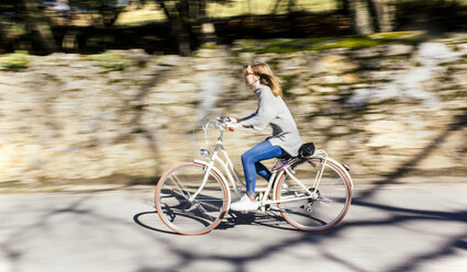 Frau fährt Fahrrad auf der Straße - MGOF001519