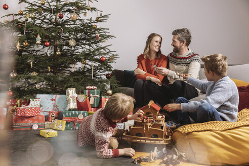 Vierköpfige Familie packt Weihnachtsgeschenke aus und spielt mit der Arche Noah - MFF002751