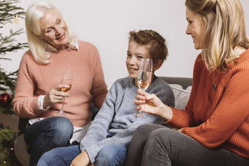 Mutter und Großmutter im Gespräch mit dem Enkel am Weihnachtsbaum - MFF002763