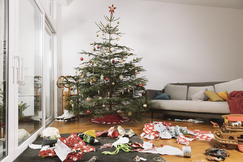 Living room on Christmas morning with torn up wrapping paper in front of the tree stock photo