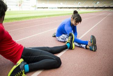 Athletes training for race in stadium - KIJF000217