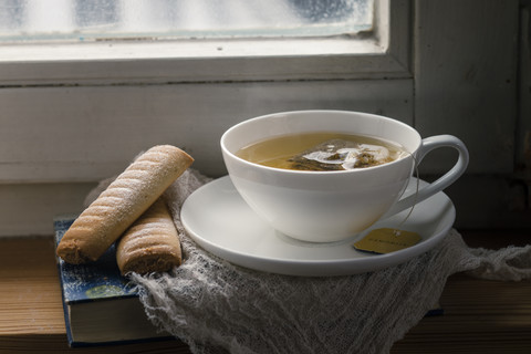 Chamomile tea and biscuits on windowbench stock photo
