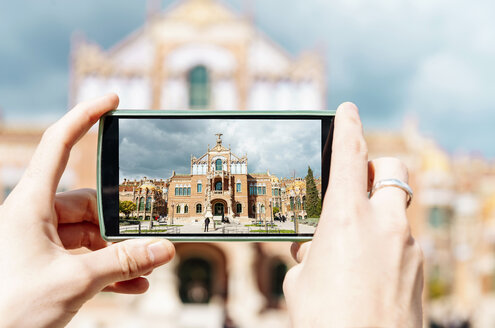 Spanien, Barcelona, Mann fotografiert Jugendstilanlage Sant Pau mit Smartphone, Nahaufnahme - GEMF000777