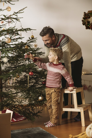 Vater und Sohn schmücken den Weihnachtsbaum, lizenzfreies Stockfoto