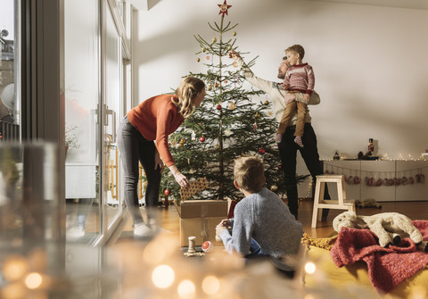 Familie beim Schmücken des Weihnachtsbaums, lizenzfreies Stockfoto