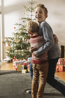 Zwei Brüder warten vor dem Weihnachtsbaum und betrachten die Geschenke - MFF002809