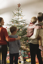 Glückliche Familie mit Blick auf den Weihnachtsbaum - MFF002812