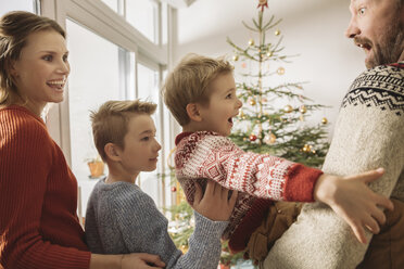 Glückliche Familie mit Blick auf den Weihnachtsbaum - MFF002813