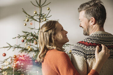 Glückliches Paar vor einem Weihnachtsbaum - MFF002817