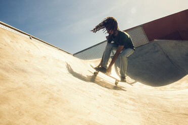 Junger Mann mit Dreadlocks auf dem Skateboard in einem Skatepark - KIJF000235