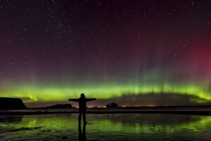 Schottland, East Lothian, Silhouette einer Frau, die am Seacliff Beach steht und Nordlichter beobachtet - SMAF000443