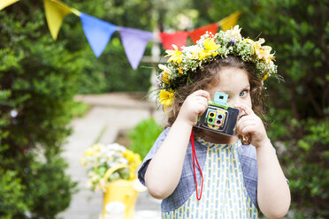 Kleines Mädchen mit Blumen, das ein Foto mit einer alten Kamera macht - VABF000295