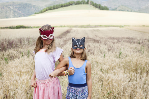 Spanien, Girona, zwei Schwestern spielen mit Tiermasken in der Natur, lizenzfreies Stockfoto