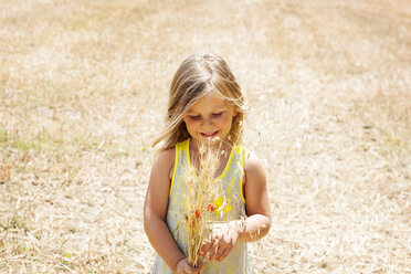 Portrait of little girl with bunch of flowers on a meadow - VABF000308
