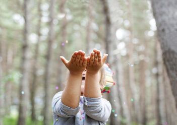 Little boy catching confetti in the woods - VABF000334