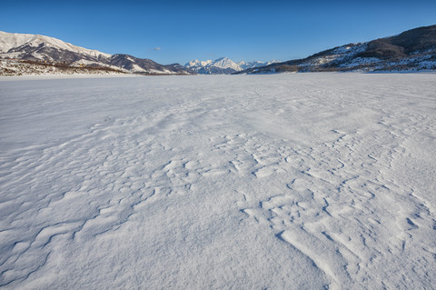 Italien, Abruzzen, Nationalpark Gran Sasso e Monti della Laga, Campotosto-See im Winter komplett zugefroren, lizenzfreies Stockfoto