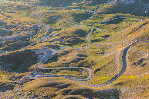 Italien, Abruzzen, Nationalpark Gran Sasso e Monti della Laga, Schlängelnde Straße auf der Hochebene Campo Imperatore bei Sonnenaufgang - LOMF000236